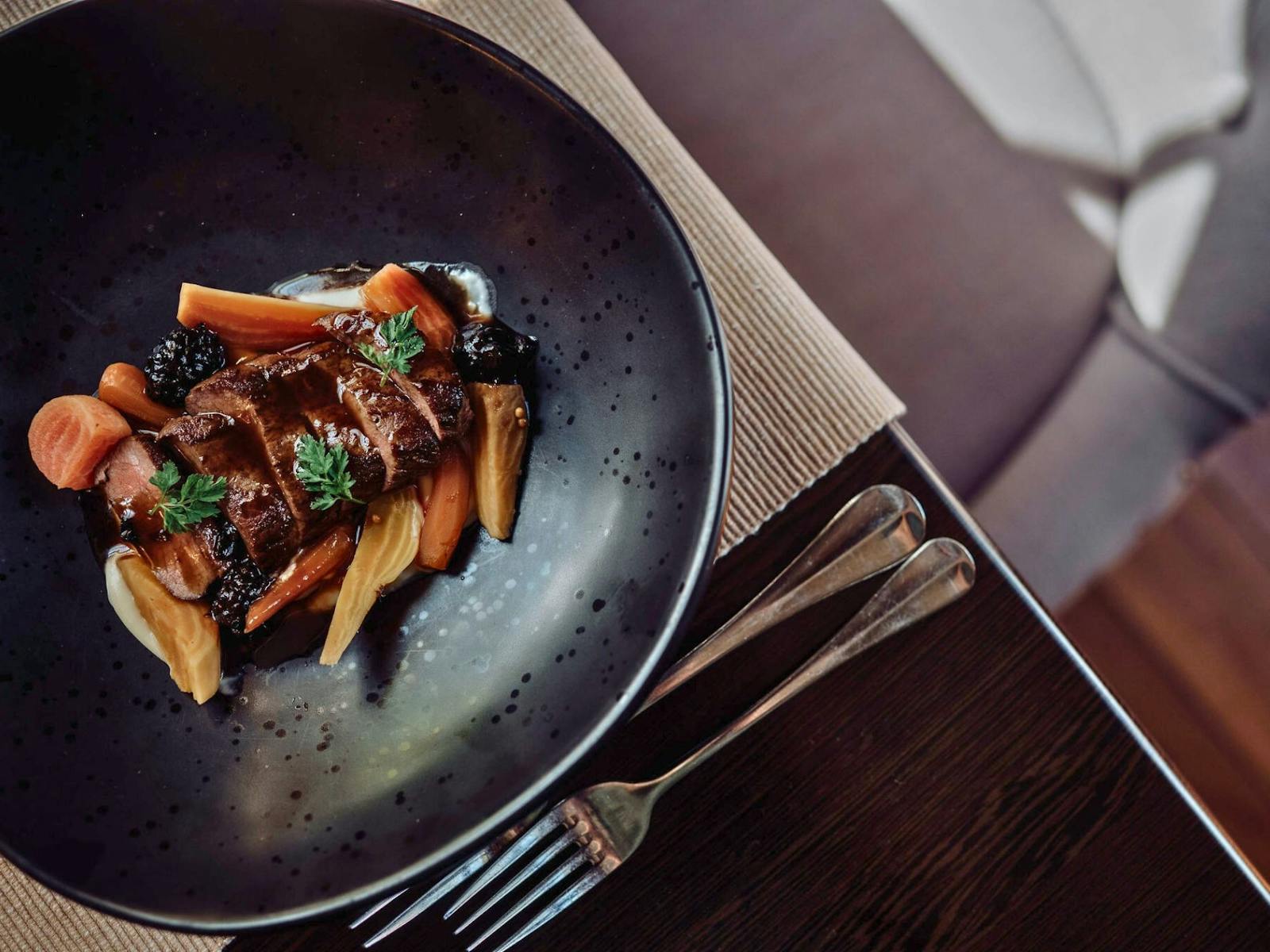 Venison meat served with carrots and wildberry jus