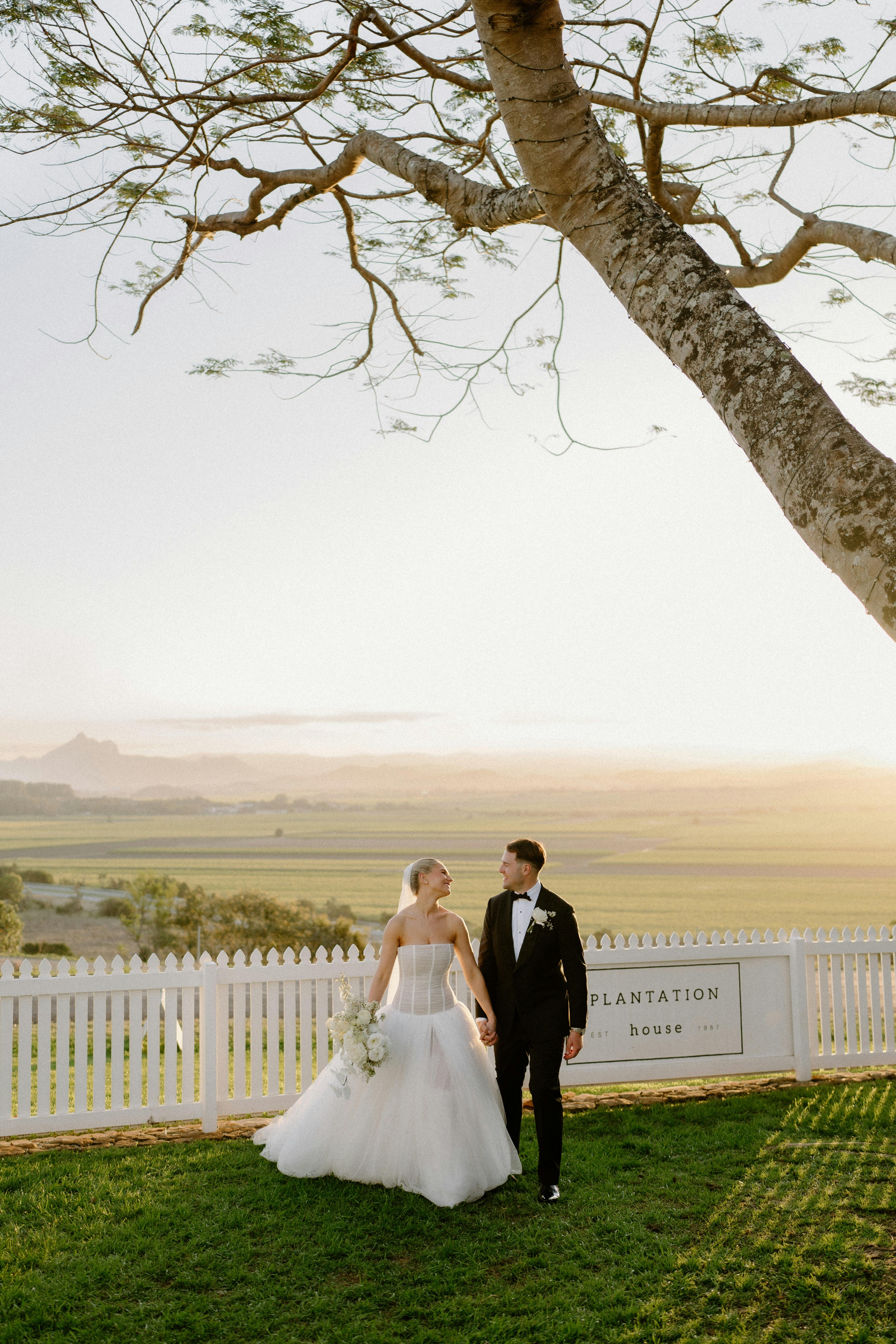 bride and groom holding hands with sweeping panoranic views in the background of the Tweed Valley