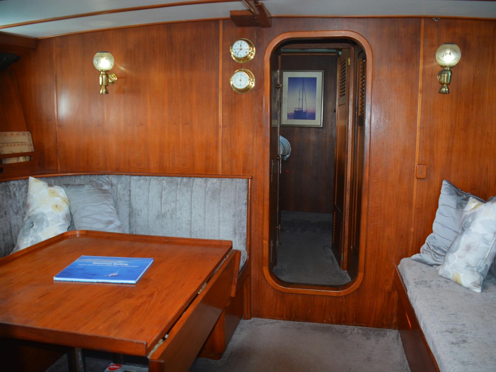 Dining area below deck features traditional seafaring teak timber work that exudes luxury &  comfort