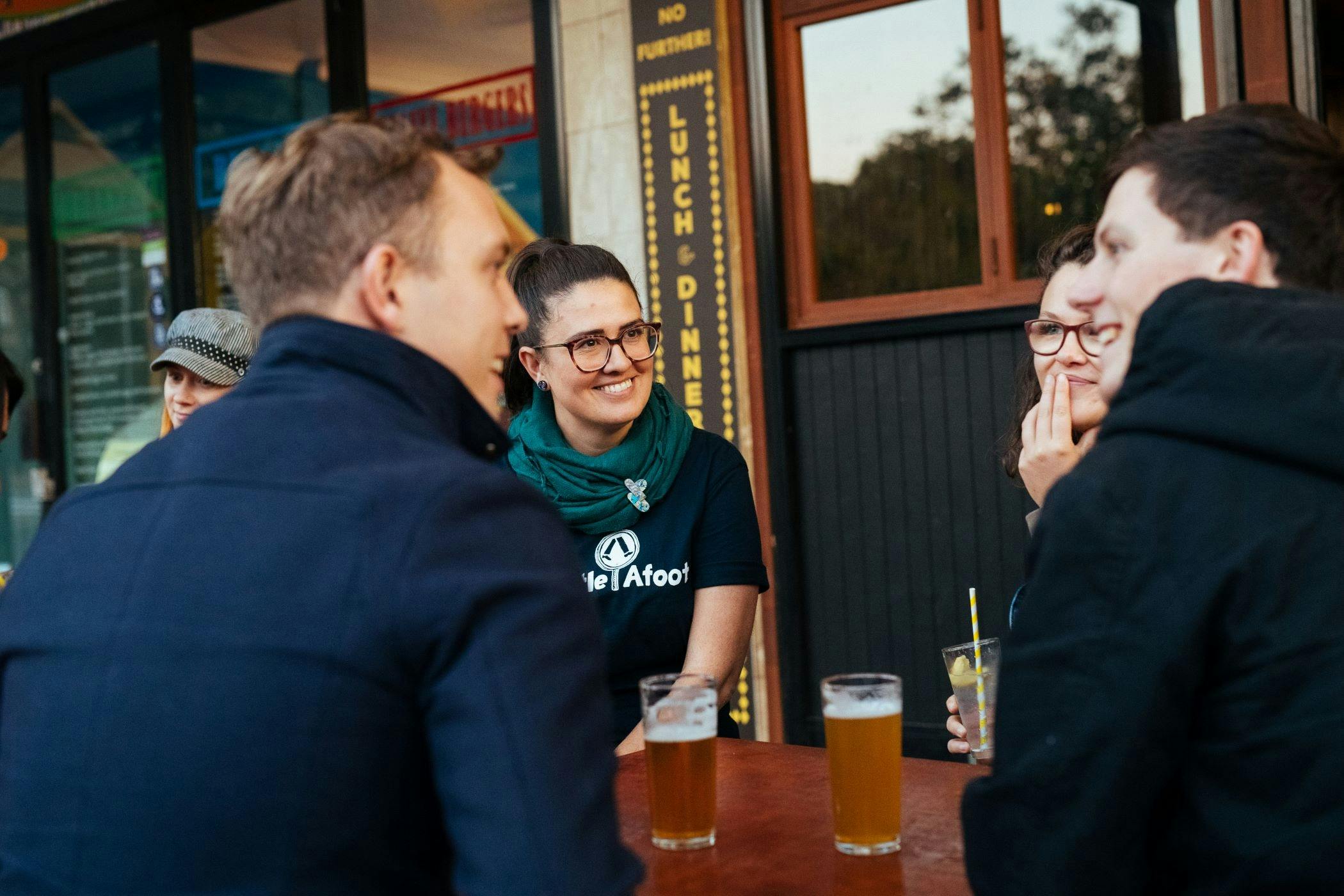 People sitting at a bar on a walking tour with a Newcastle Afoot guide. Having a beer and laughing.