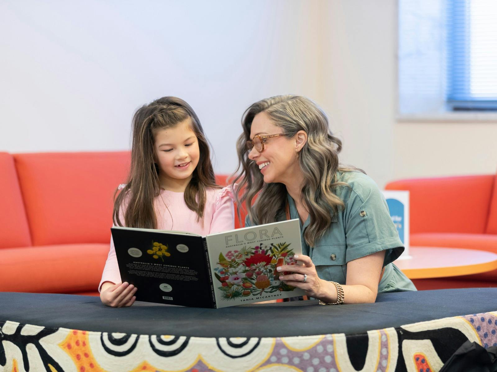 A woman and a young girl reading a book in the National Library's Main Reading Room