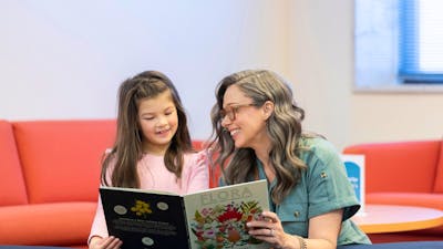 A woman and a young girl reading a book in the National Library's Main Reading Room