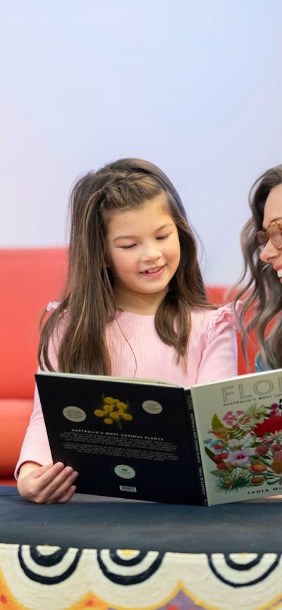 A woman and a young girl reading a book in the National Library's Main Reading Room