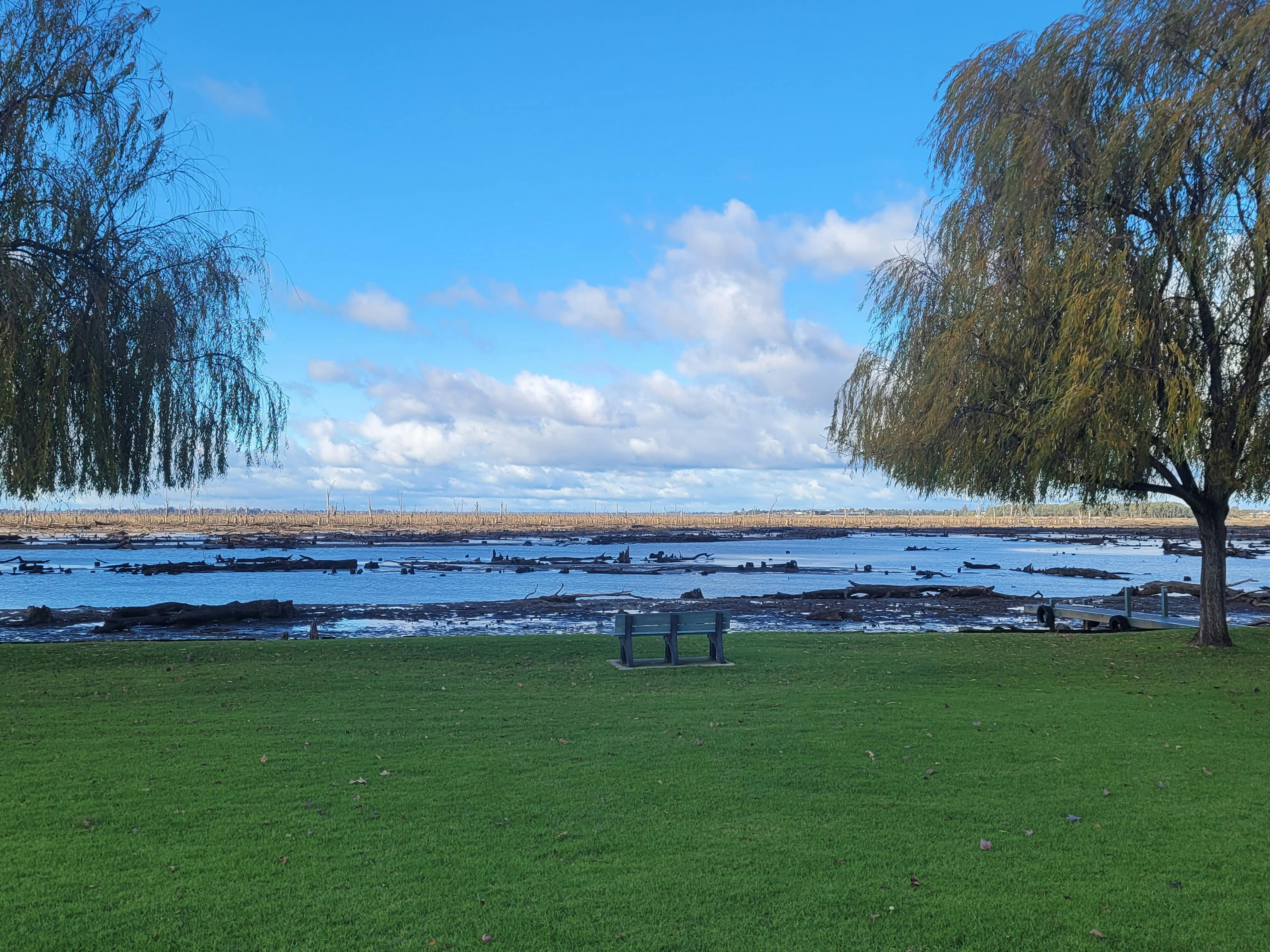 Clear blue skies lush green grass water from lake Muwlala