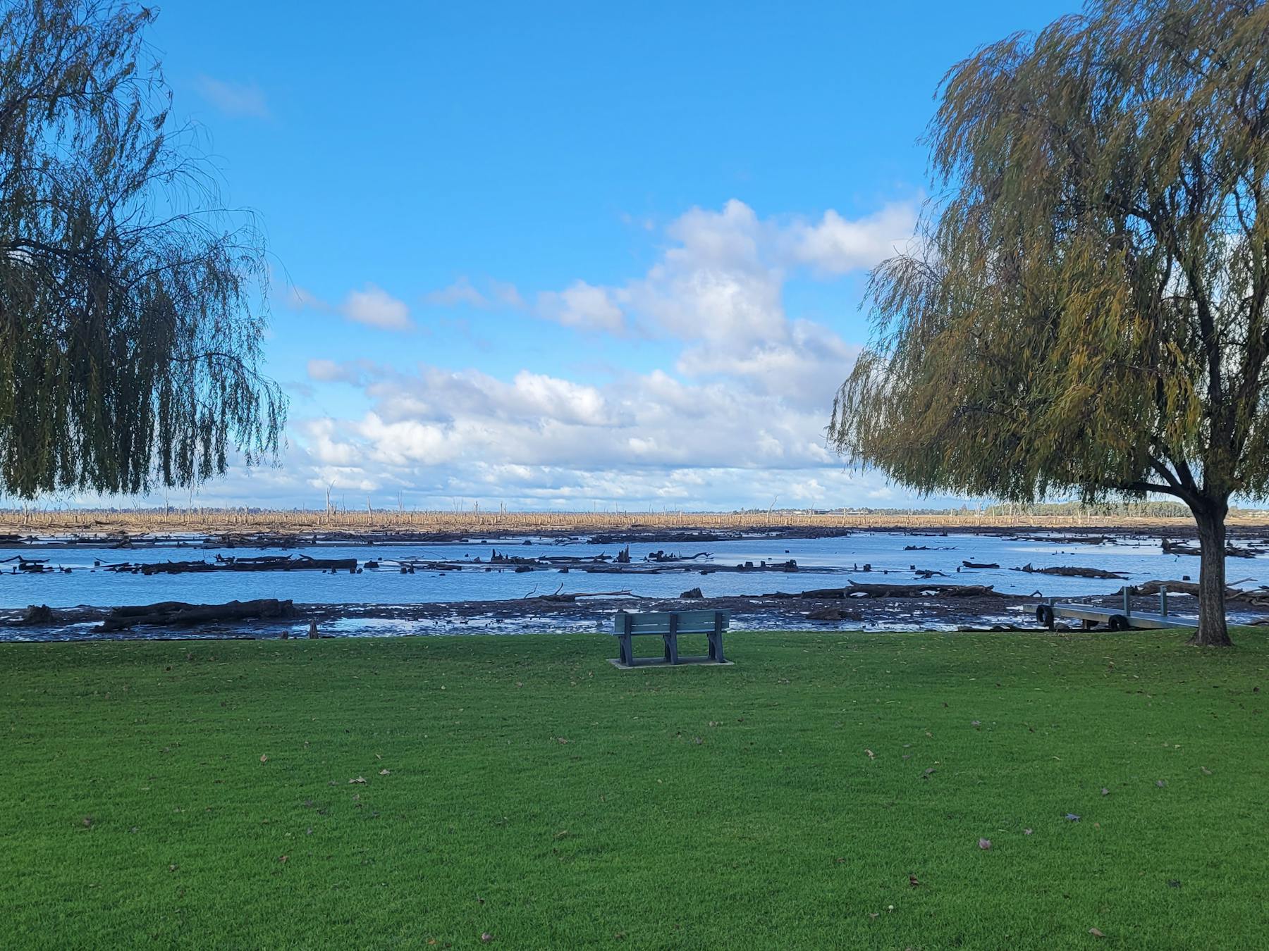 Clear blue skies lush green grass water from lake Muwlala