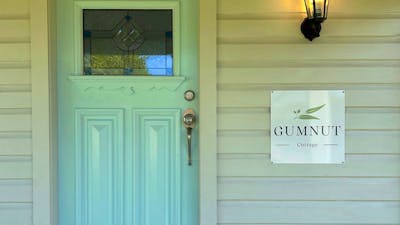 A blue door with stained glass, a lantern, and a sign reading