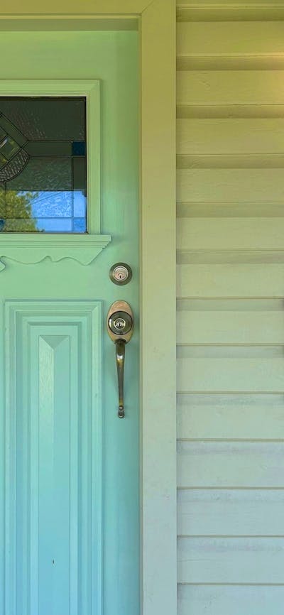 A blue door with stained glass, a lantern, and a sign reading