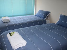 Bedroom with 2 single beds  and towels rolled up on beds