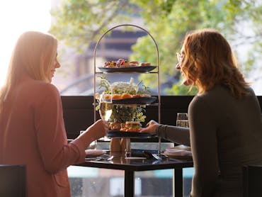 Two woman enjoyining an afternoon tea ta Lennons Restaurant & Bar in Hyatt Regency Brisbane.