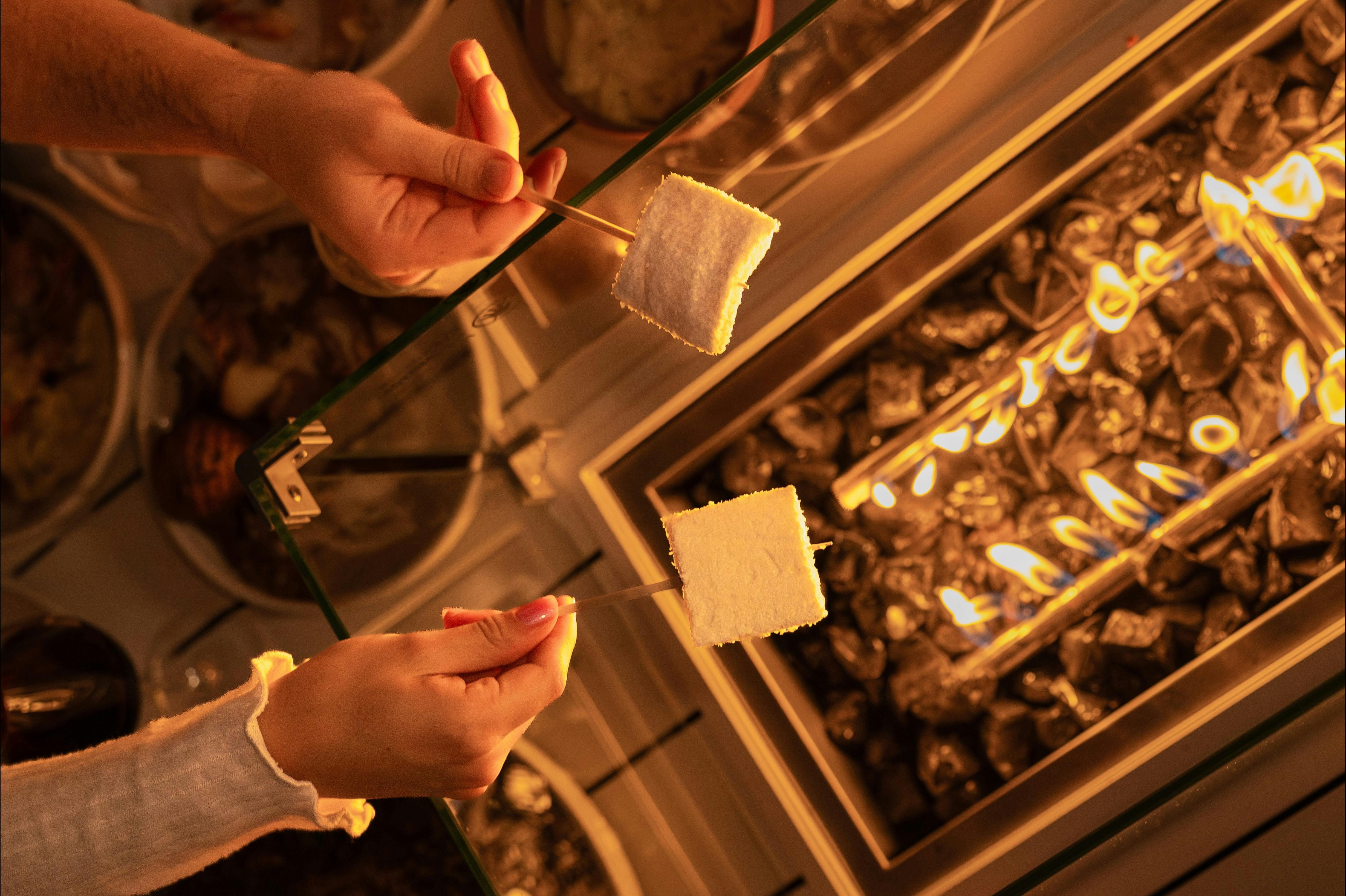 firepit table with people toasting marshmallows