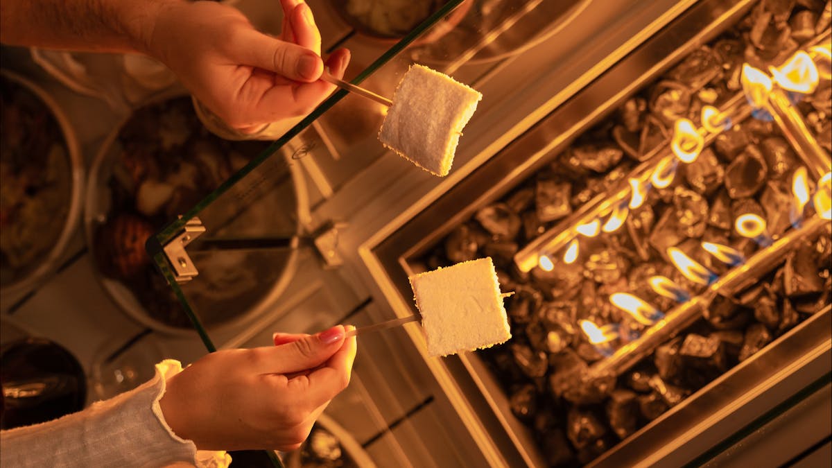 firepit table with people toasting marshmallows