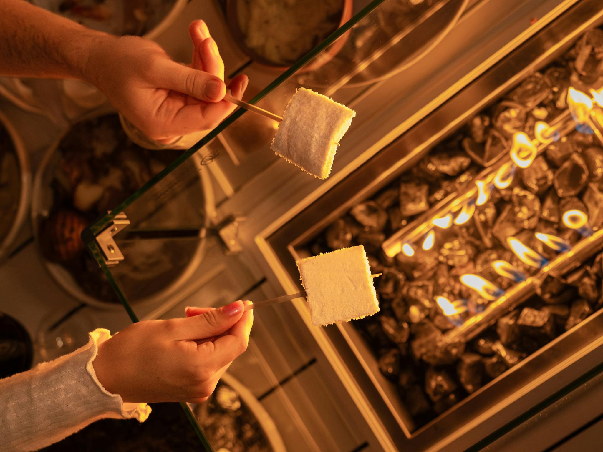 firepit table with people toasting marshmallows firepit table with people toasting marshmallows