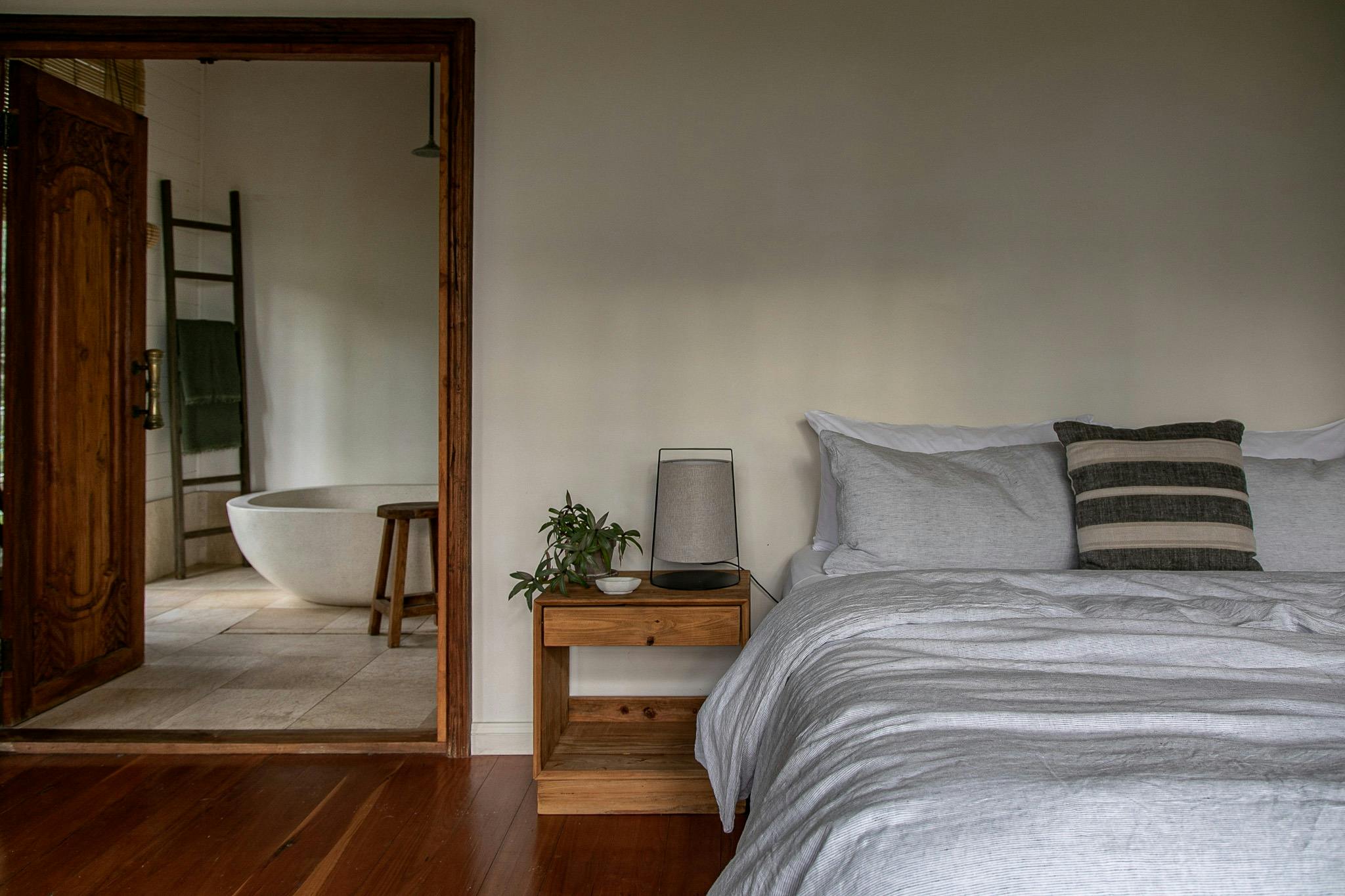 a king bed with ensuite with stone bath and lovely linens