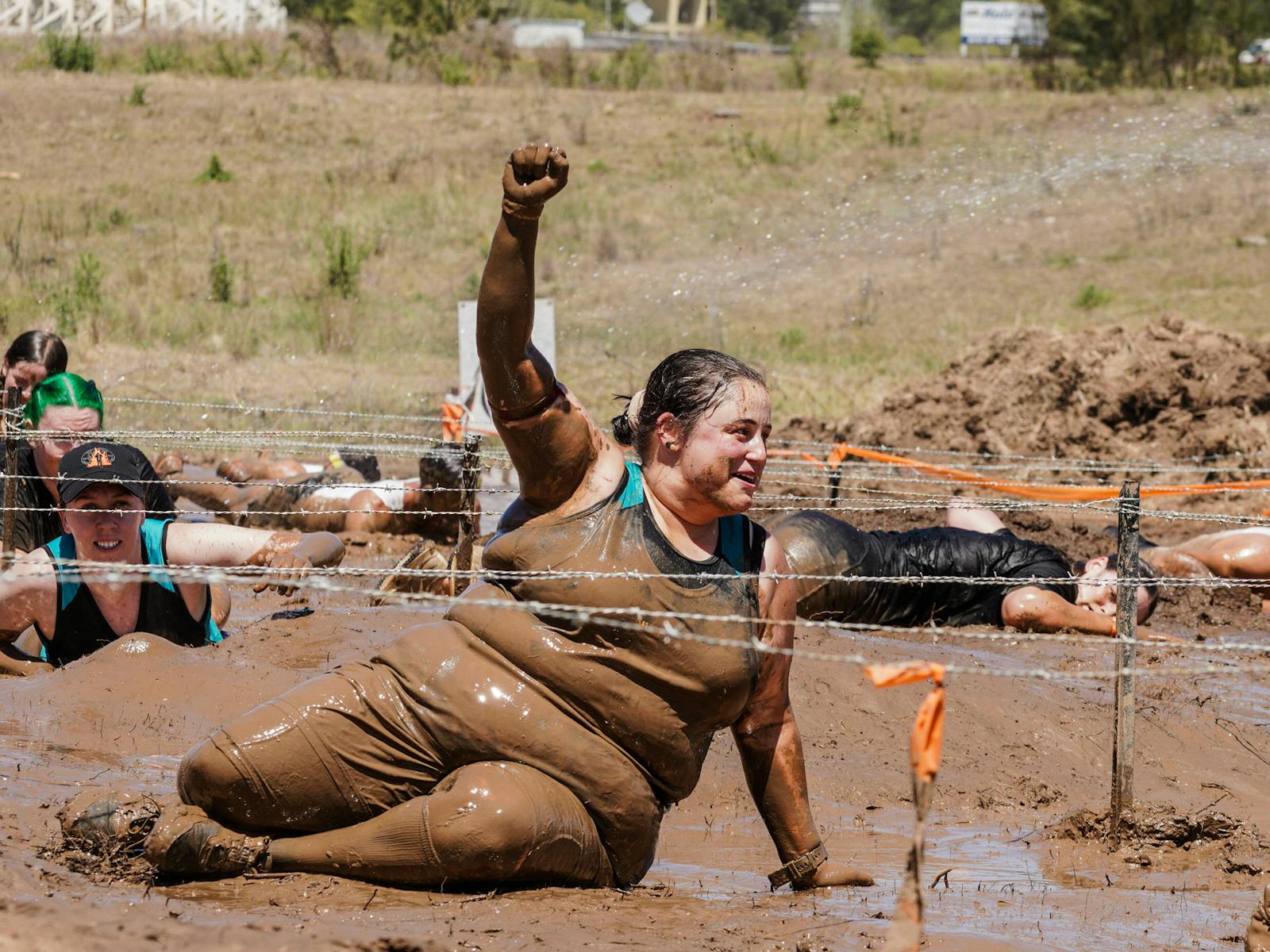 Fist pump in the air by a Mudder doing the barbed wire crawl