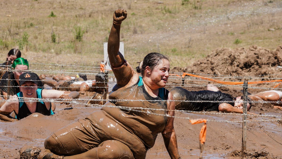 Fist pump in the air by a Mudder doing the barbed wire crawl