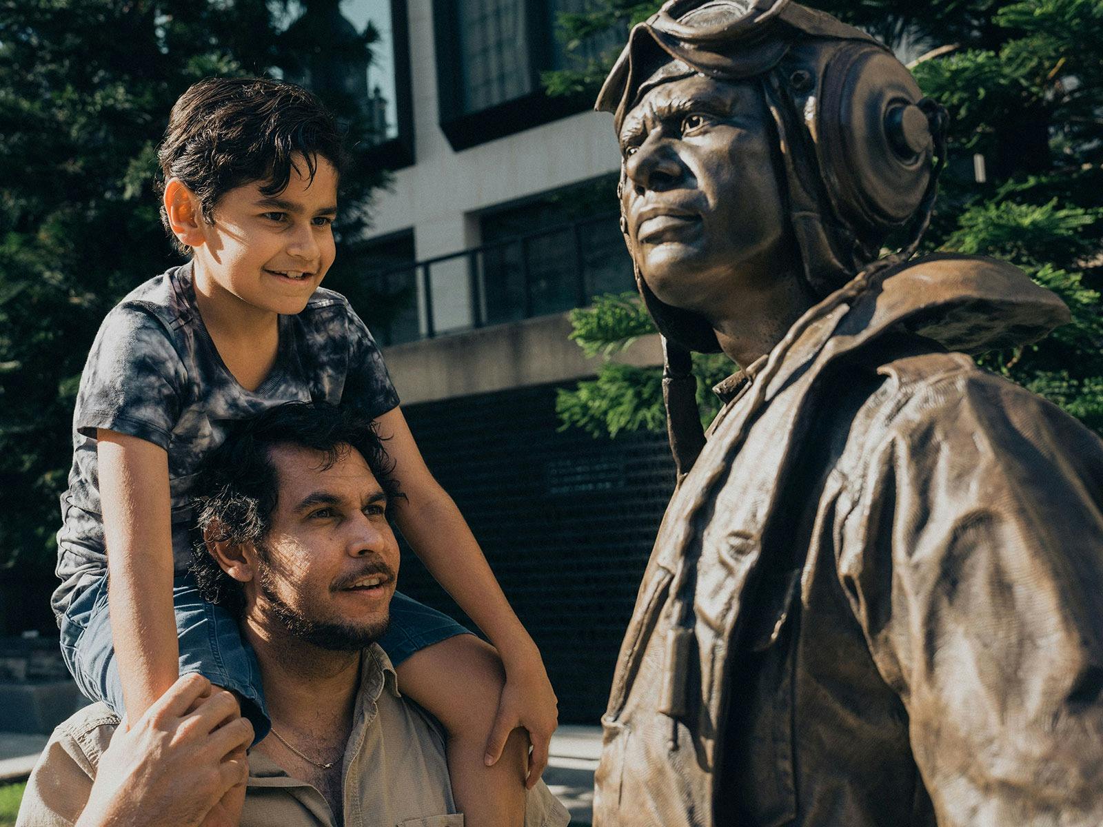 Father and young son admiring the Indigenous Memorial in the Anzac Square parklands