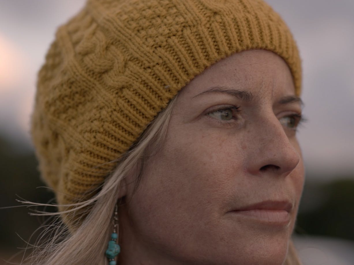 close up of woman looking to the side wearing a beanie