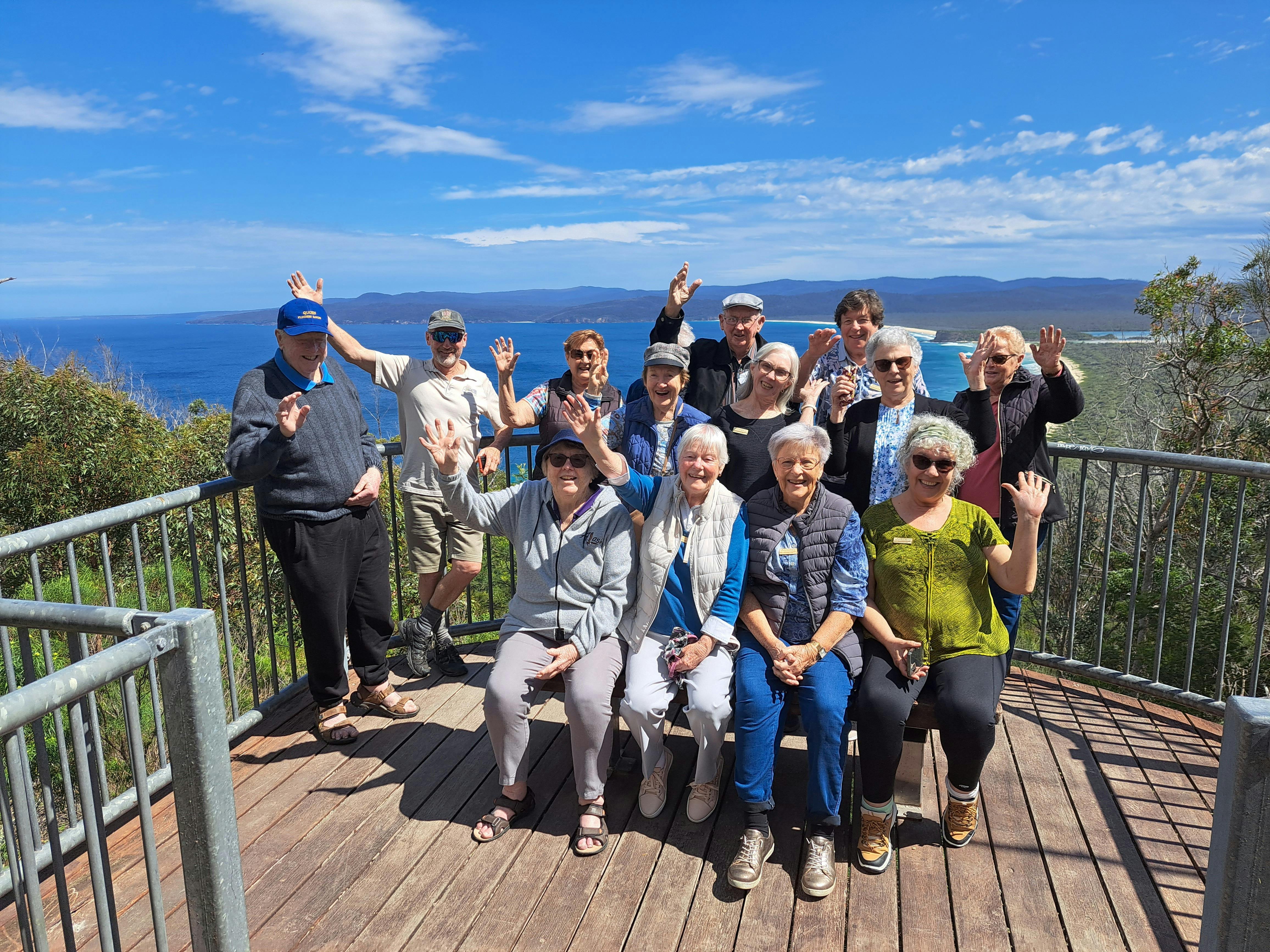 several seniors on lookout platform with ocean and bay behind