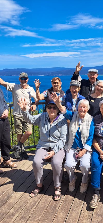 several seniors on lookout platform with ocean and bay behind