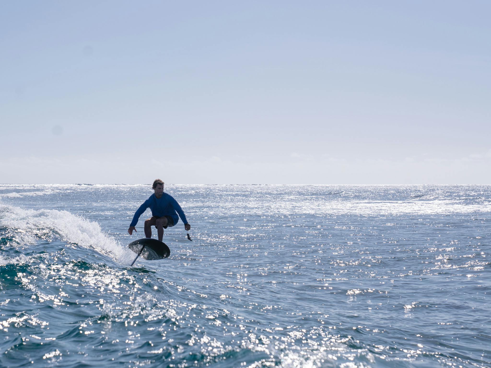 man on Fliteboard catching a wave efoiling man on Fliteboard catching a wave efoiling