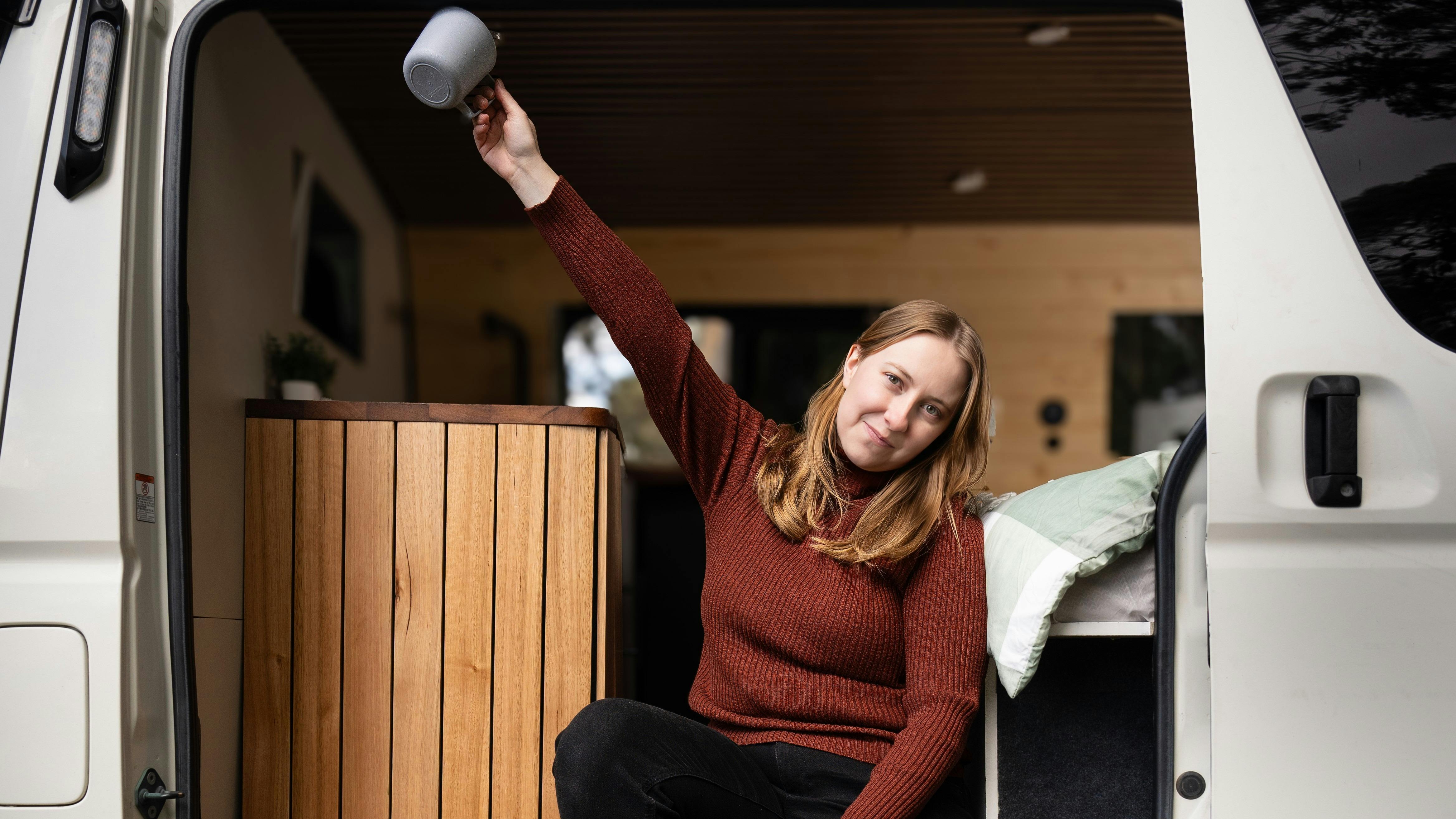 Cheerful moment inside Yana 4WD van, embracing spontaneous van life adventure.