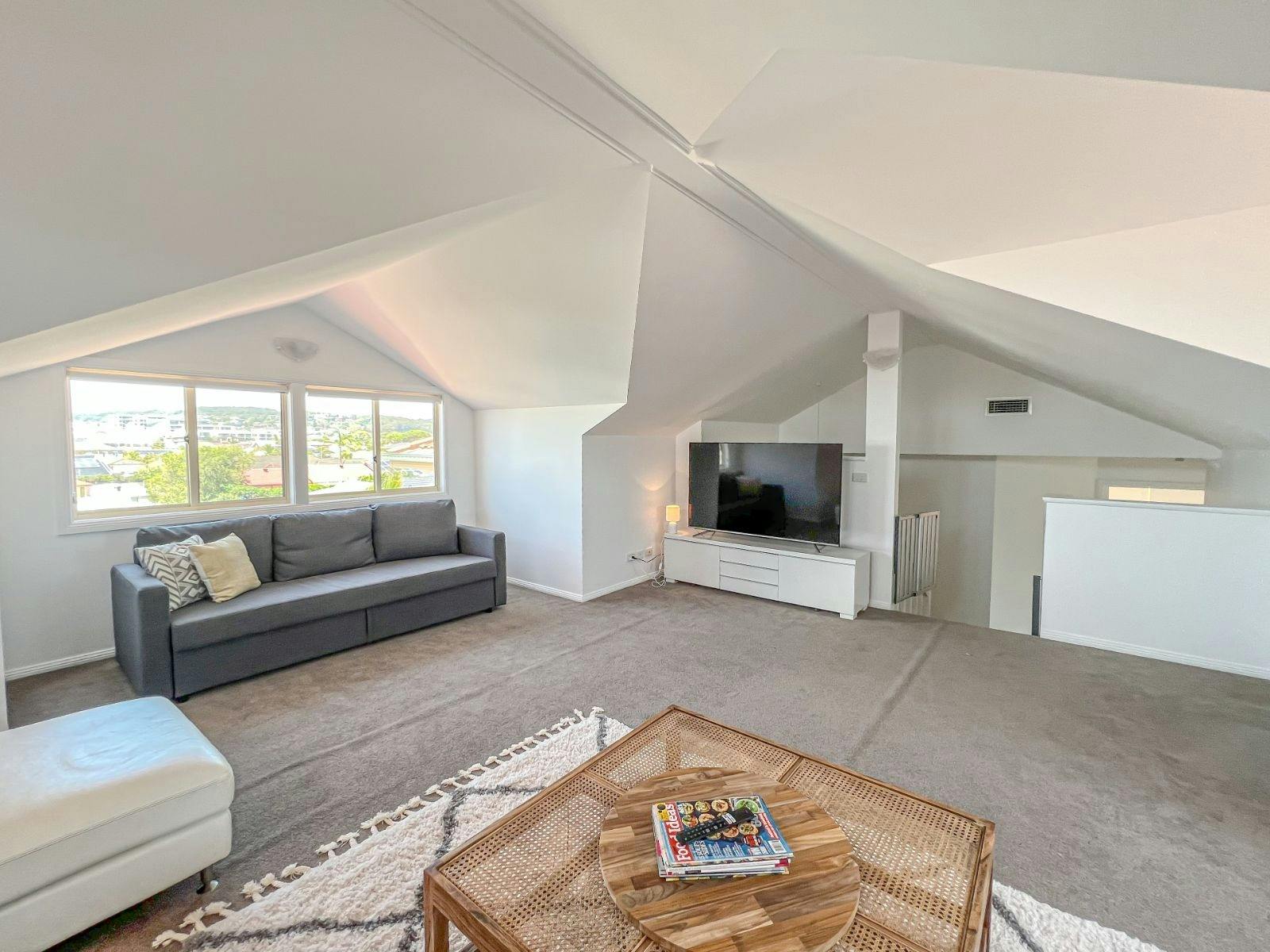 The upstairs attic room with its soaring ceiling is a stunning light filled space to get away from i