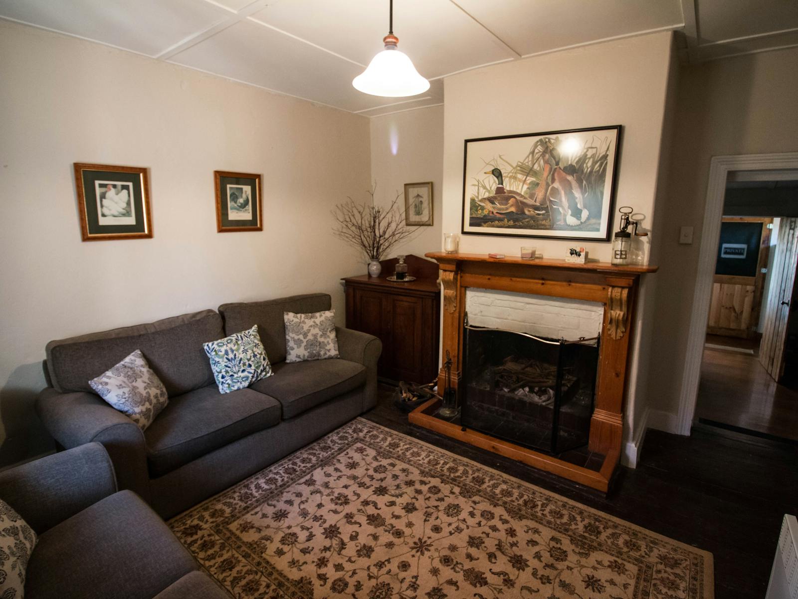 the living room of old farm cottage with open fireplace and comfortable lounges