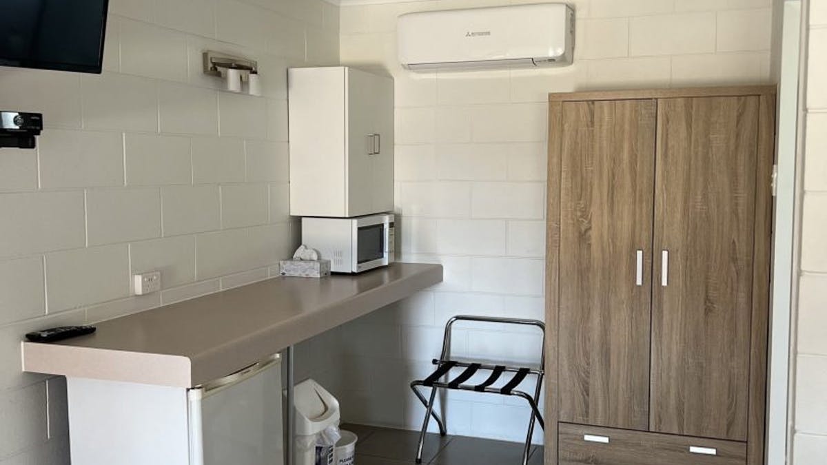 Kitchenette with a microwave, fridge and storage cupboard