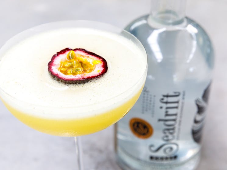 A shot of a Pornstar martini cocktail with half a fresh passionfruit