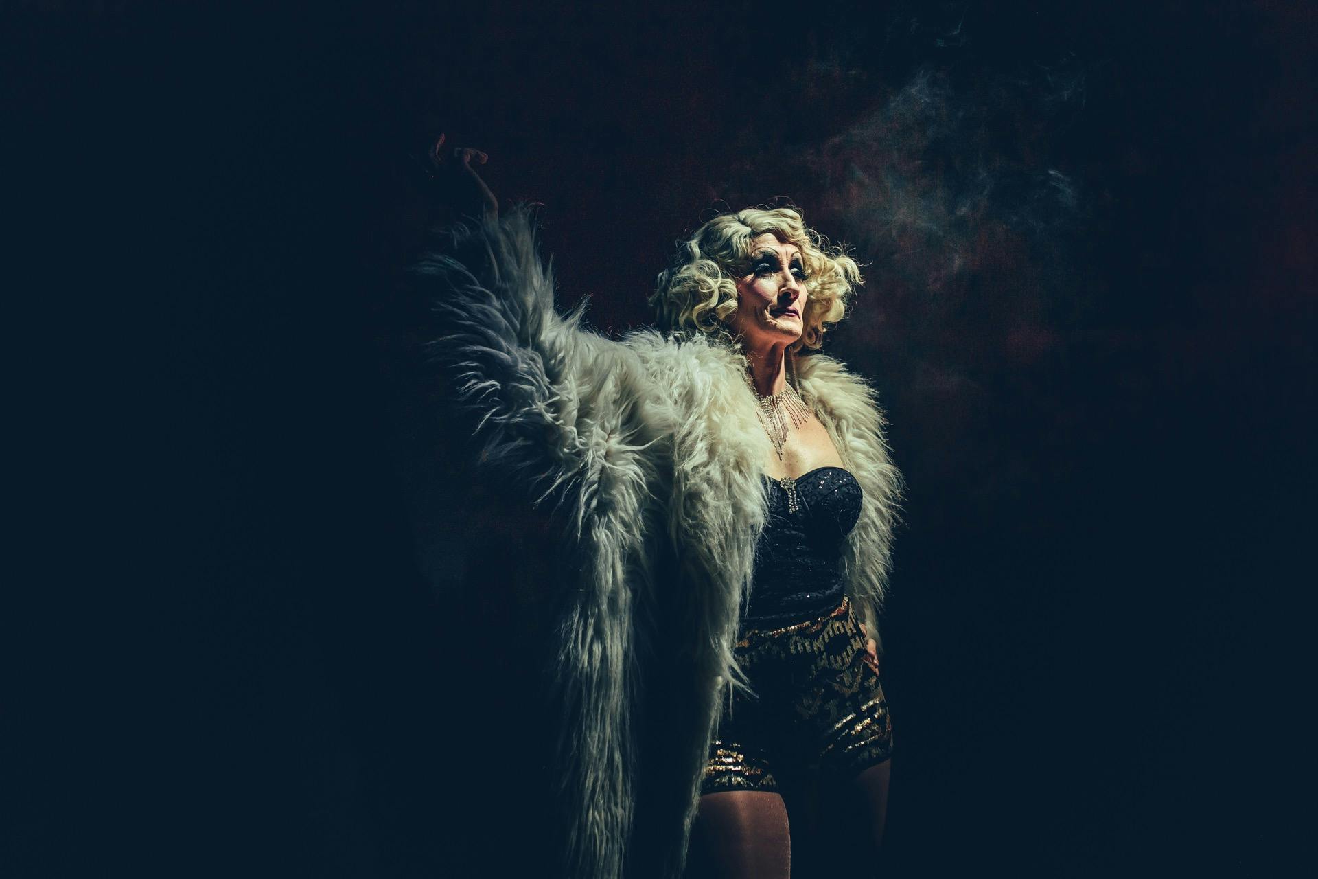 Blonde woman in white fur coat onstage