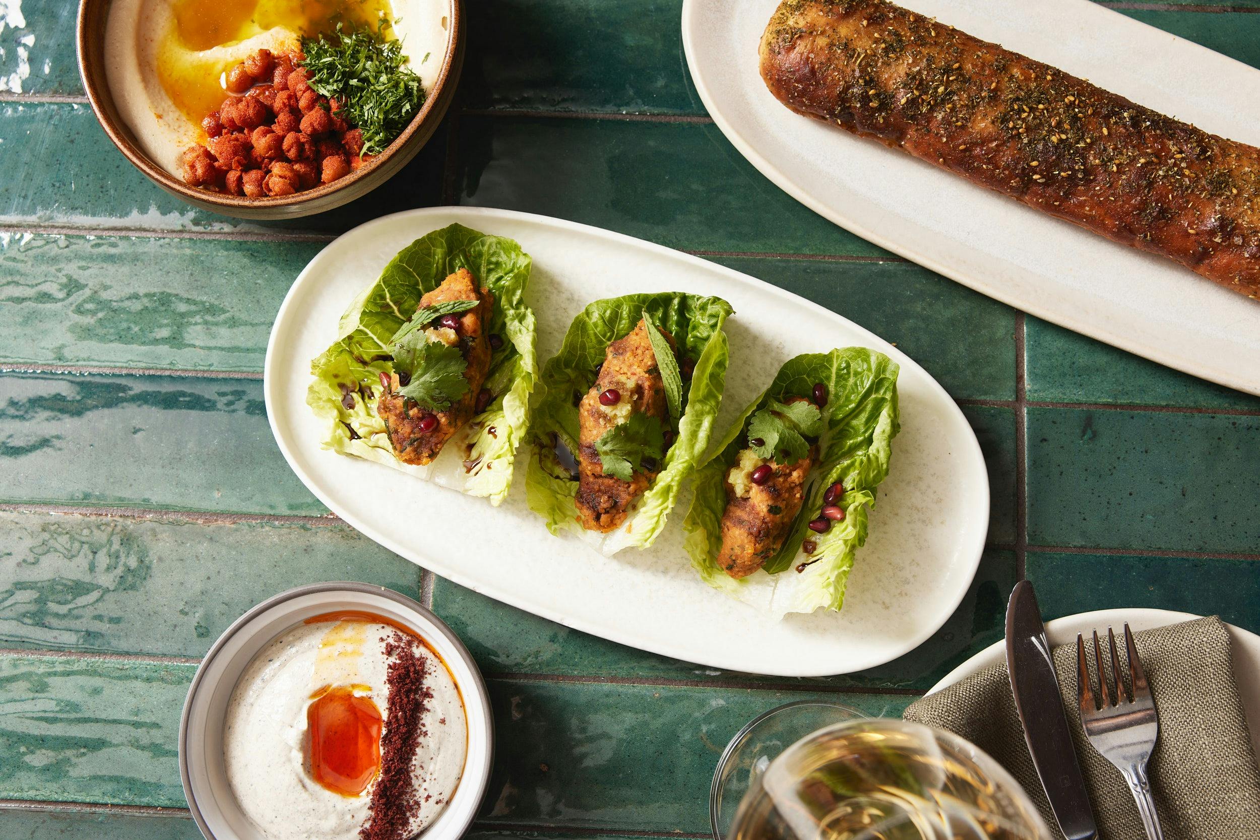 A Middle Eastern spread of plant-based dish, focaccia, hummus and labneh.