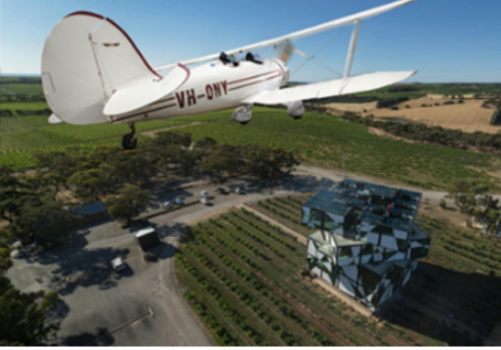 Biplane flying over the d'Arenberg Cube