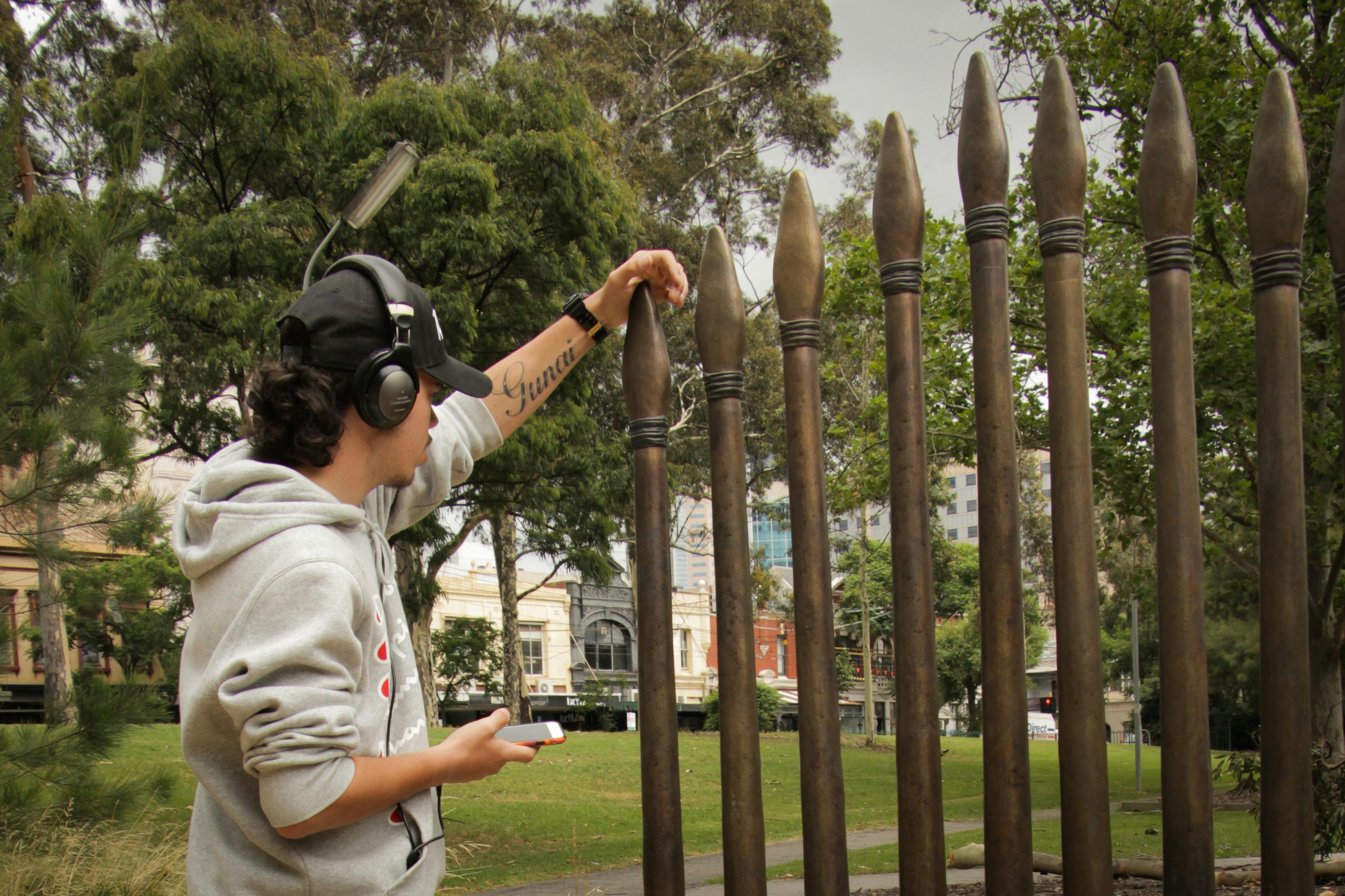 BJ listening to the Yalinguth app at the Stolen Generations Marker, Atherton Gardens, Fitzroy