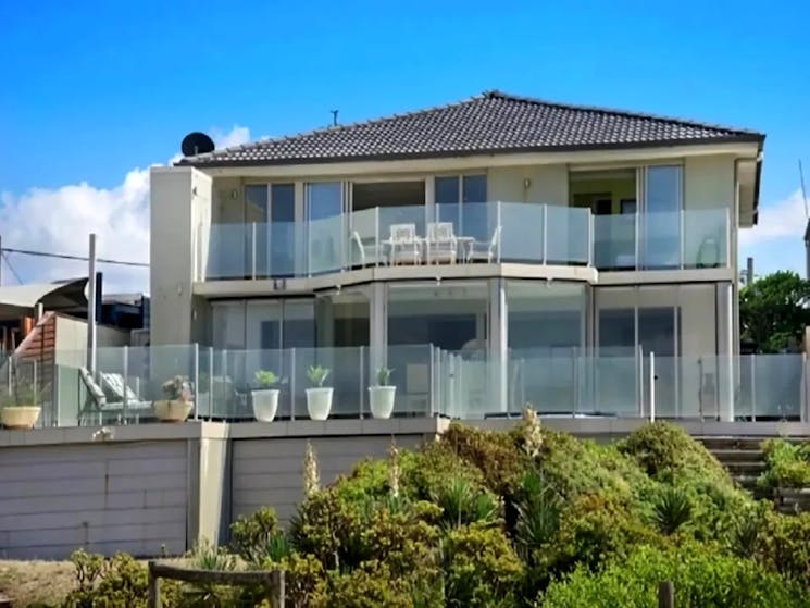 exceptionally modern, spacious, and light-filled home boasts a spectacular ocean-front location