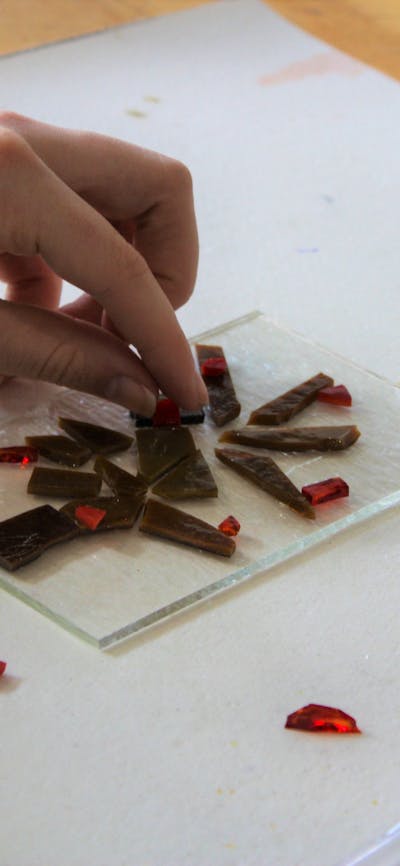Visitor arranging glass on a tile