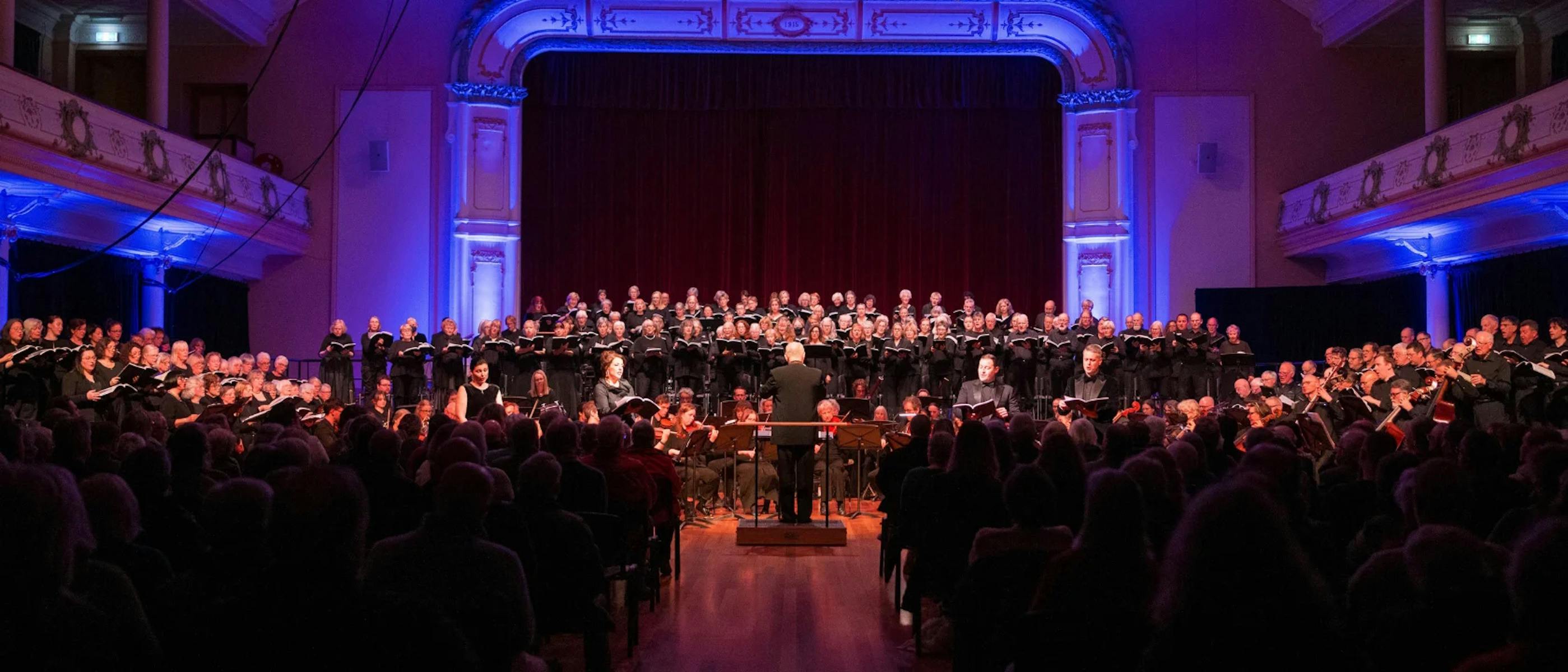 A group of singers on stage in front of a seated audience
