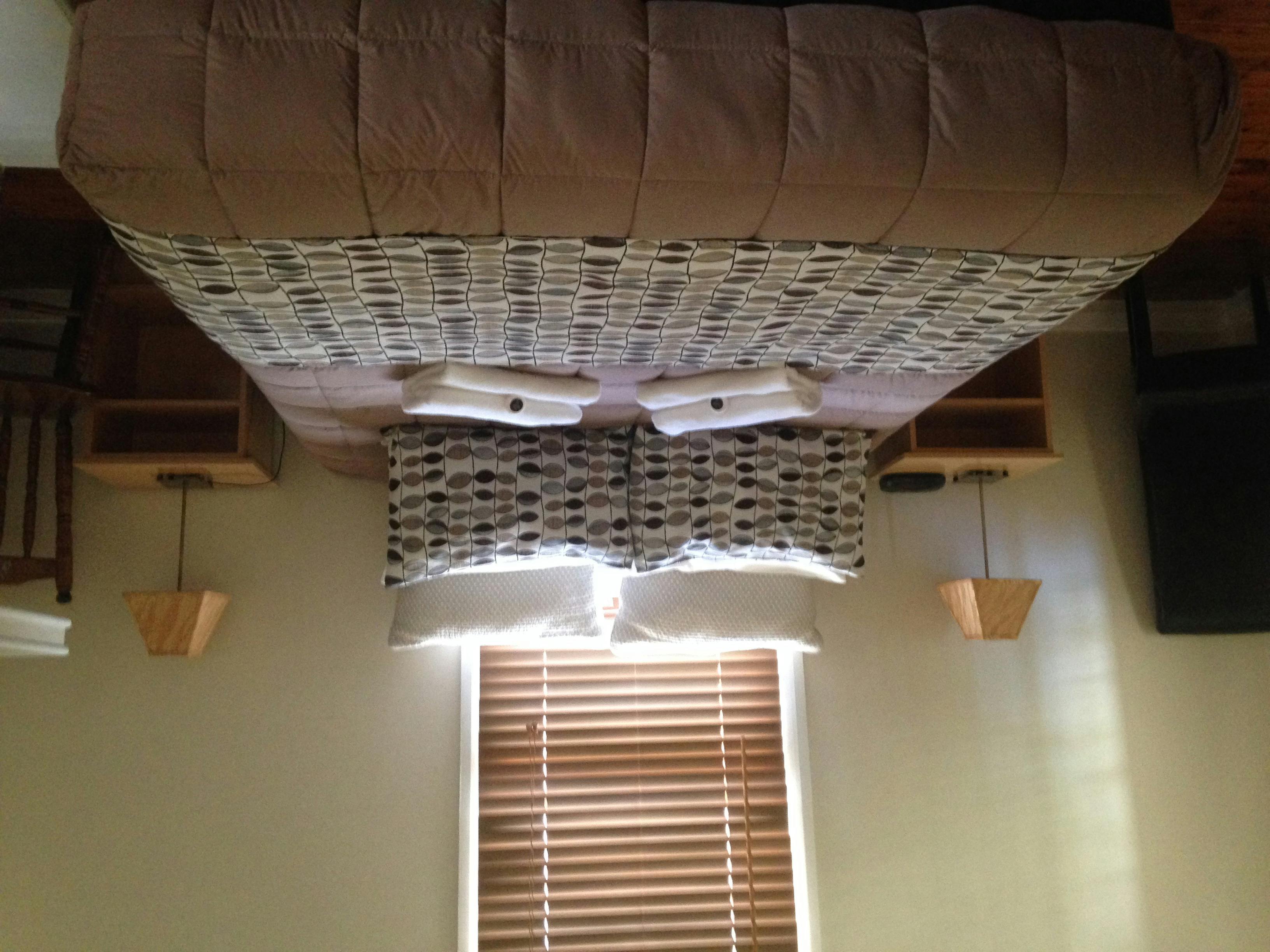 ベッドサイドテーブルとベッドの両側にランプが付いたベッド。