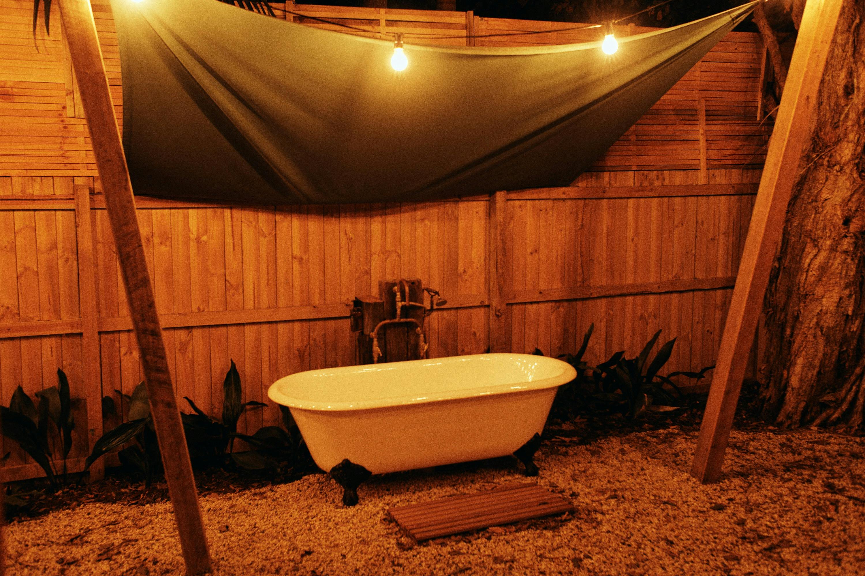Bungalow garden at The Sunseeker, Byron Bay; outdoor bath under fairy lights