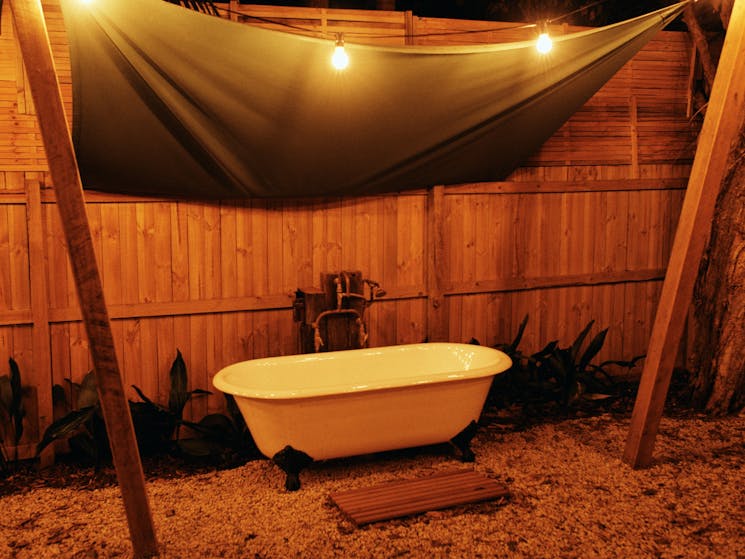 Bungalow garden at The Sunseeker, Byron Bay; outdoor bath under fairy lights