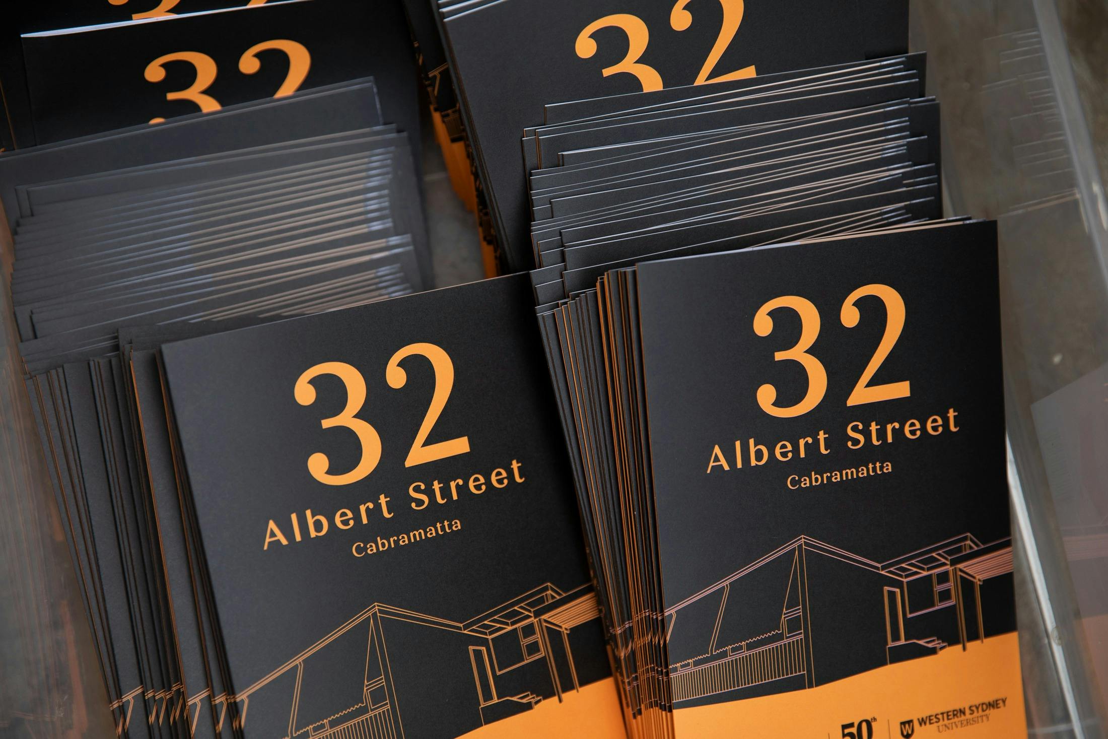 A box filled with A6 brochures about the history of the house