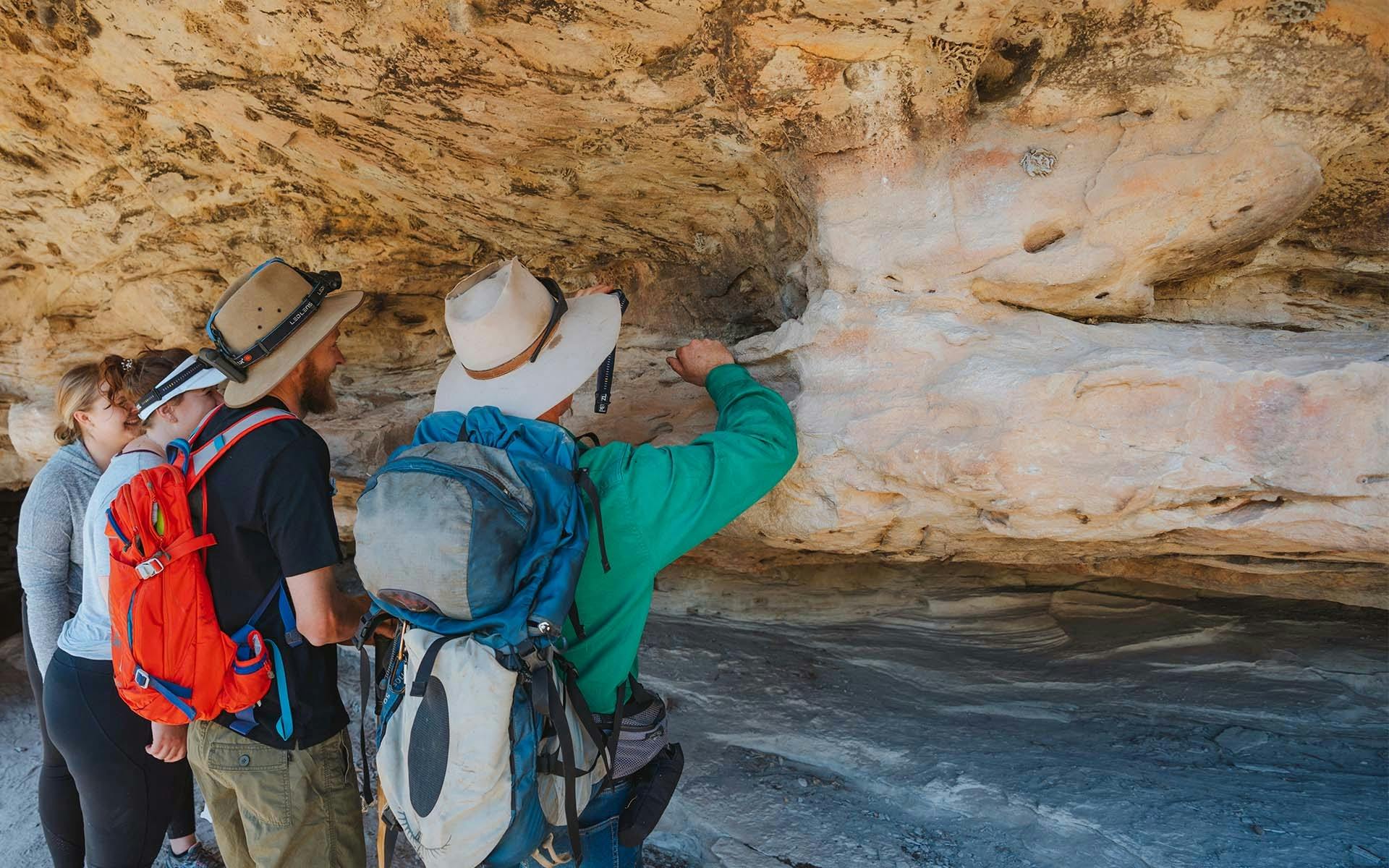A tour guide showing guests features of a sandstone cave
