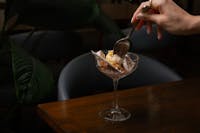 Hand with spoon in ice cream bowl