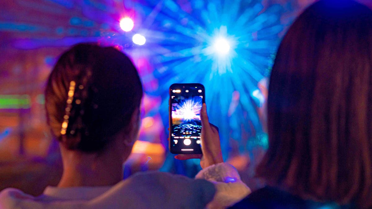 Girl taking photo of the laser light show