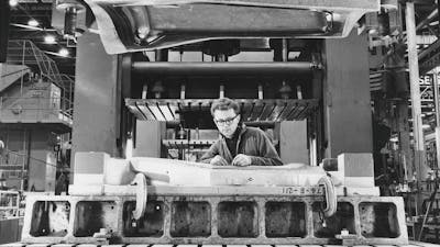 Black and white photograph of of a mechanic working on a Holden car
