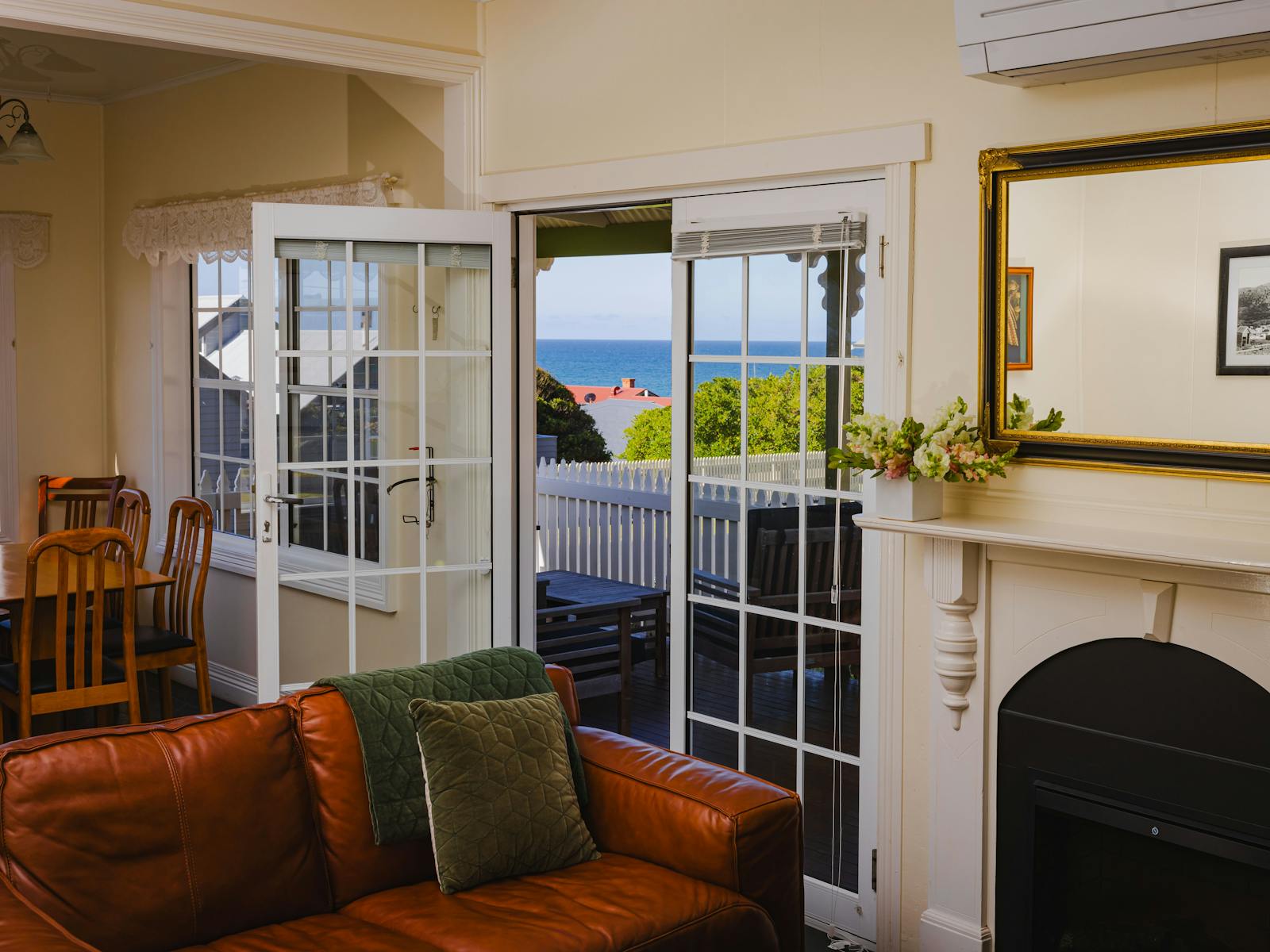 Electric wood fire look heater, air conditioning and heat pump, comfy arm chairs and sofa, dining