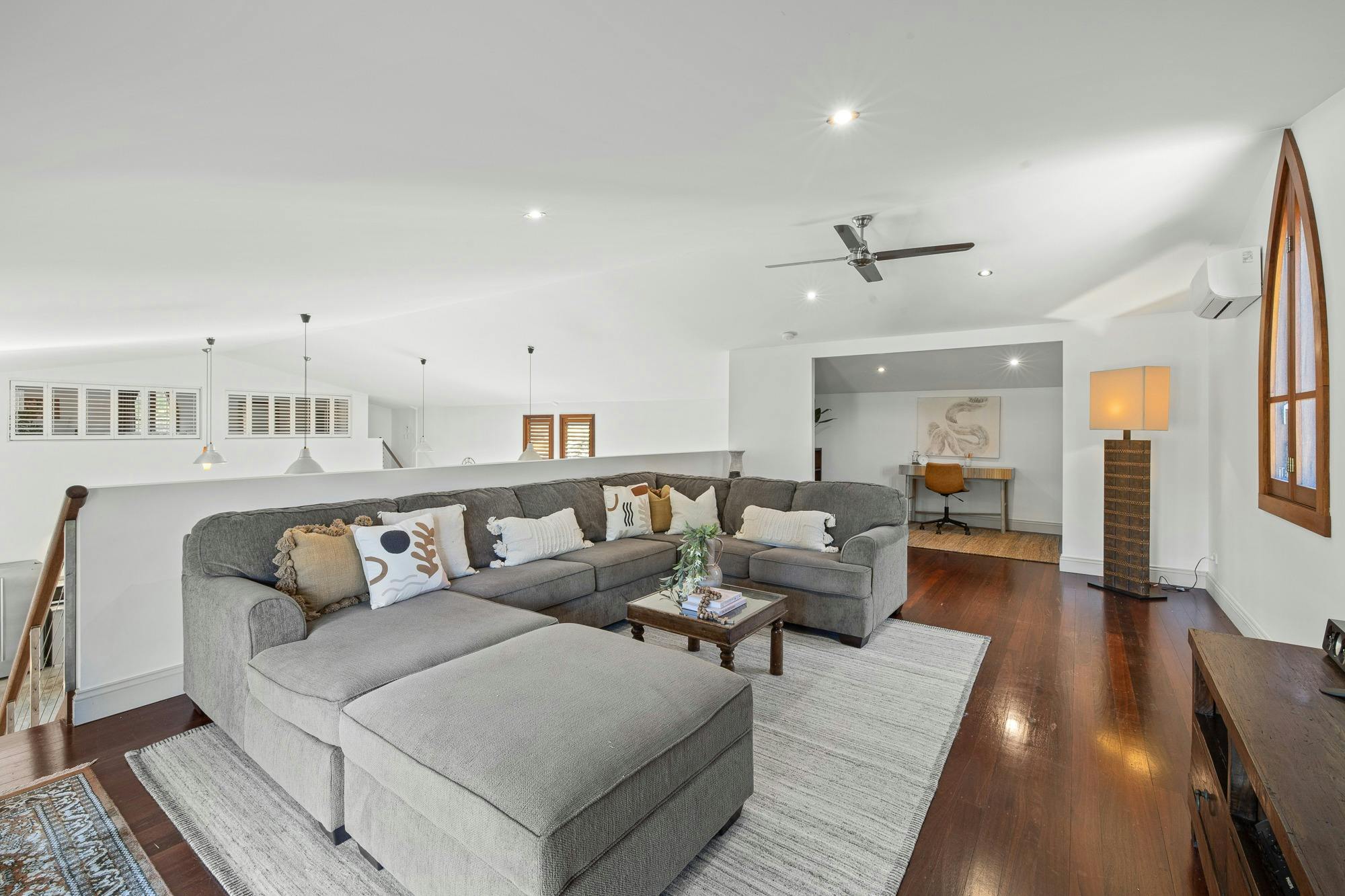 Spacious open-plan living area with modern furnishings, cozy seating, and natural light