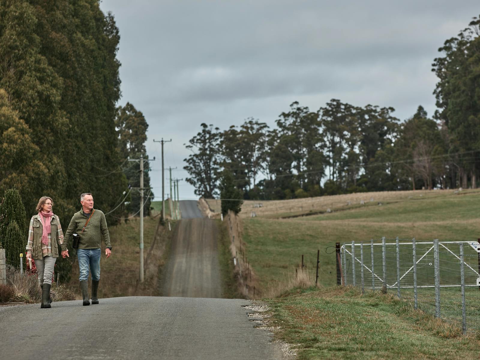 Man and woman walking along quiet country road