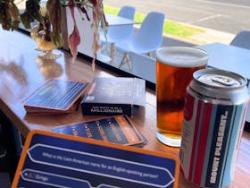 Window seating with trivia game and a glass of Belmont Common