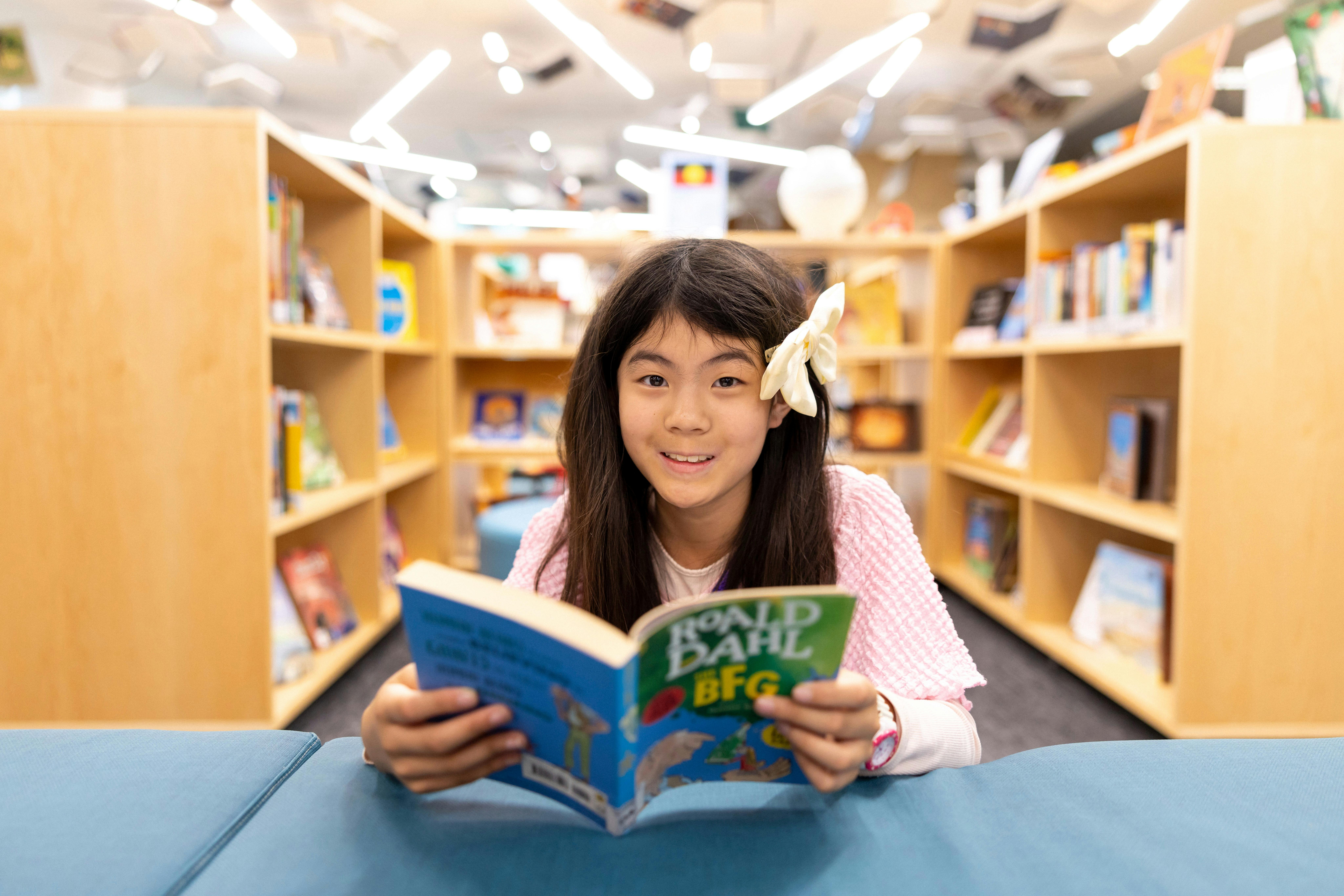 Young girl reading a book in a Children's Library