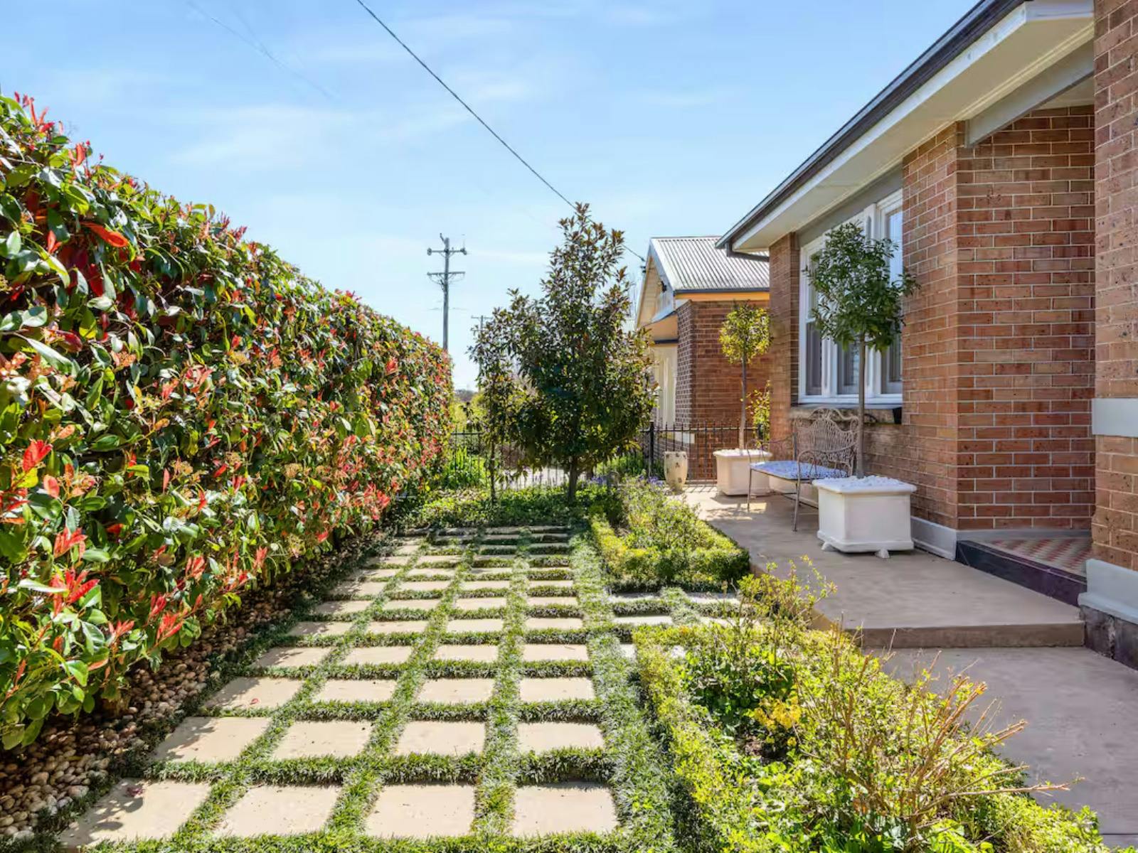 Clean garden with pavers and lush plants to welcome guests.